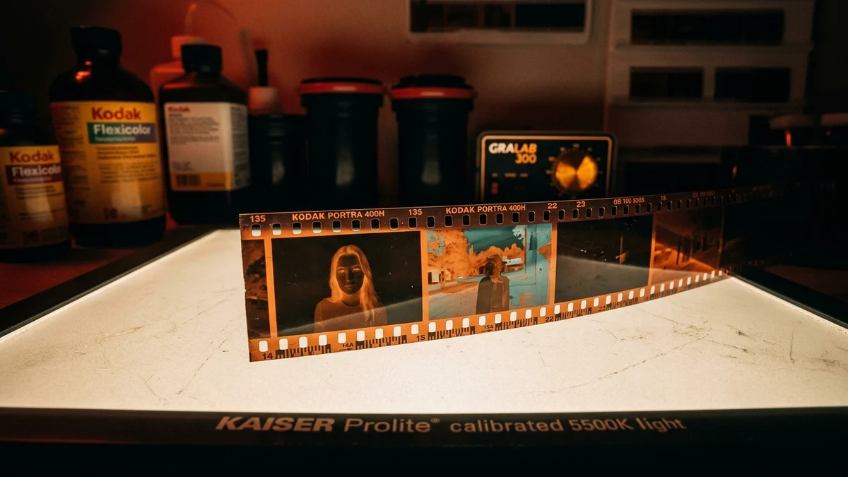 Analog darkroom laboratory workstation with film processing chemistry, timer, and optical light table