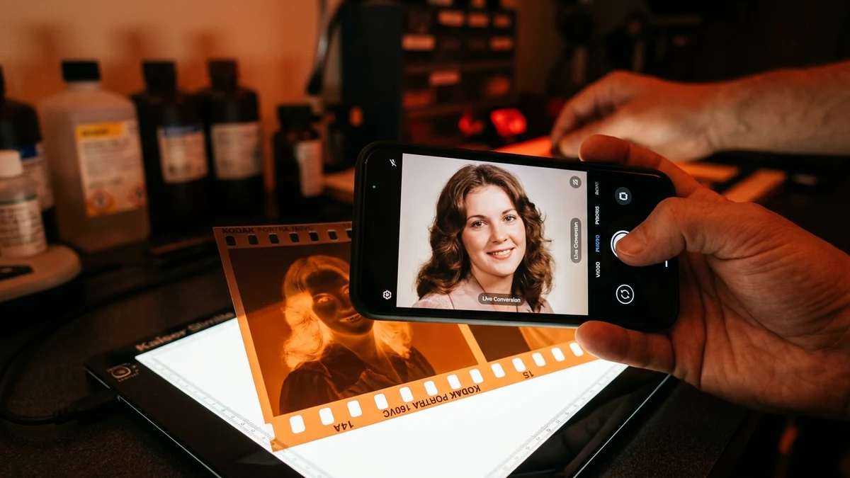 Close-up of smartphone camera screen inverting film negative into true-color positive in real-time